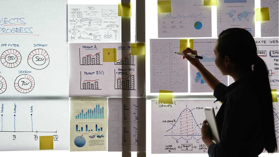 Mulher em quadro realizando gestão ágil de projetos